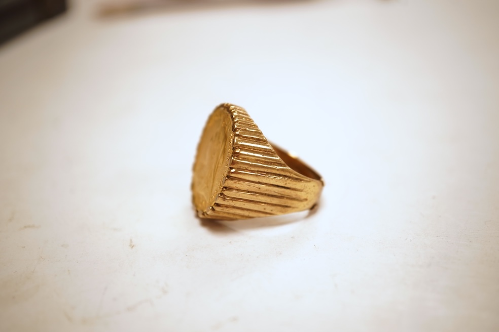 A sovereign ring, 1897 and later, set with a full sovereign dated 1897, to a fluted gold ring mount, size S (sizing band), ring mount stamped 9ct, gross weight 17 grams, Condition: typical surface wear